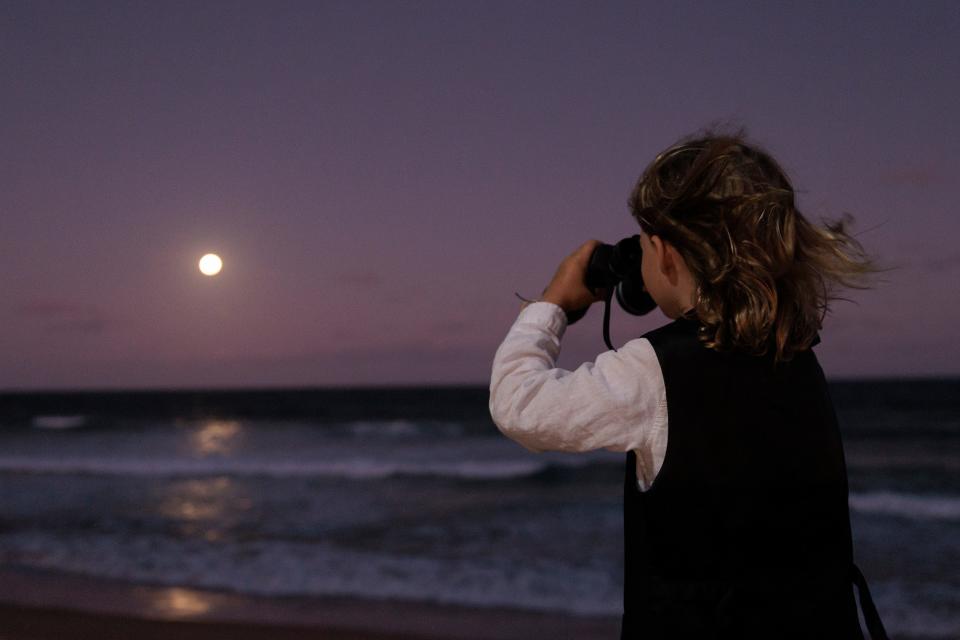 A young boy looks out to the moon on Manly beach as a partial eclipse of the Moon begins on Nov. 8, 2022 in Sydney, Australia.