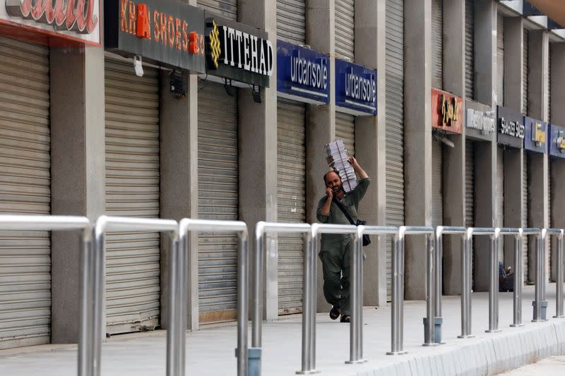 Man walks past closed market during a partial lockdown amid the COVID-19 outbreak in Karachi