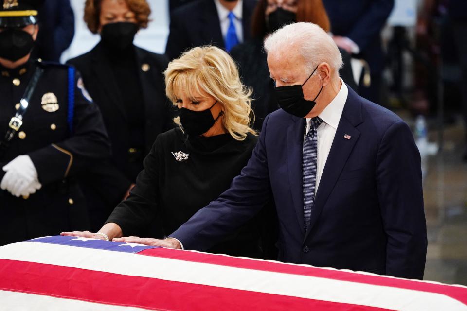 President Biden and first lady Jill Biden touch the casket of the late Sen. Bob Dole during a ceremony in the Capitol Rotunda on Thursday. 