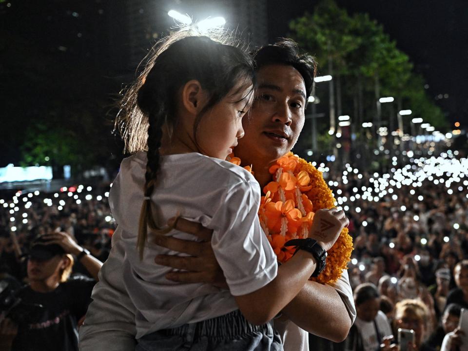 Pita Limjaroenrat holds his daughter on stage during a rally in Bangkok.