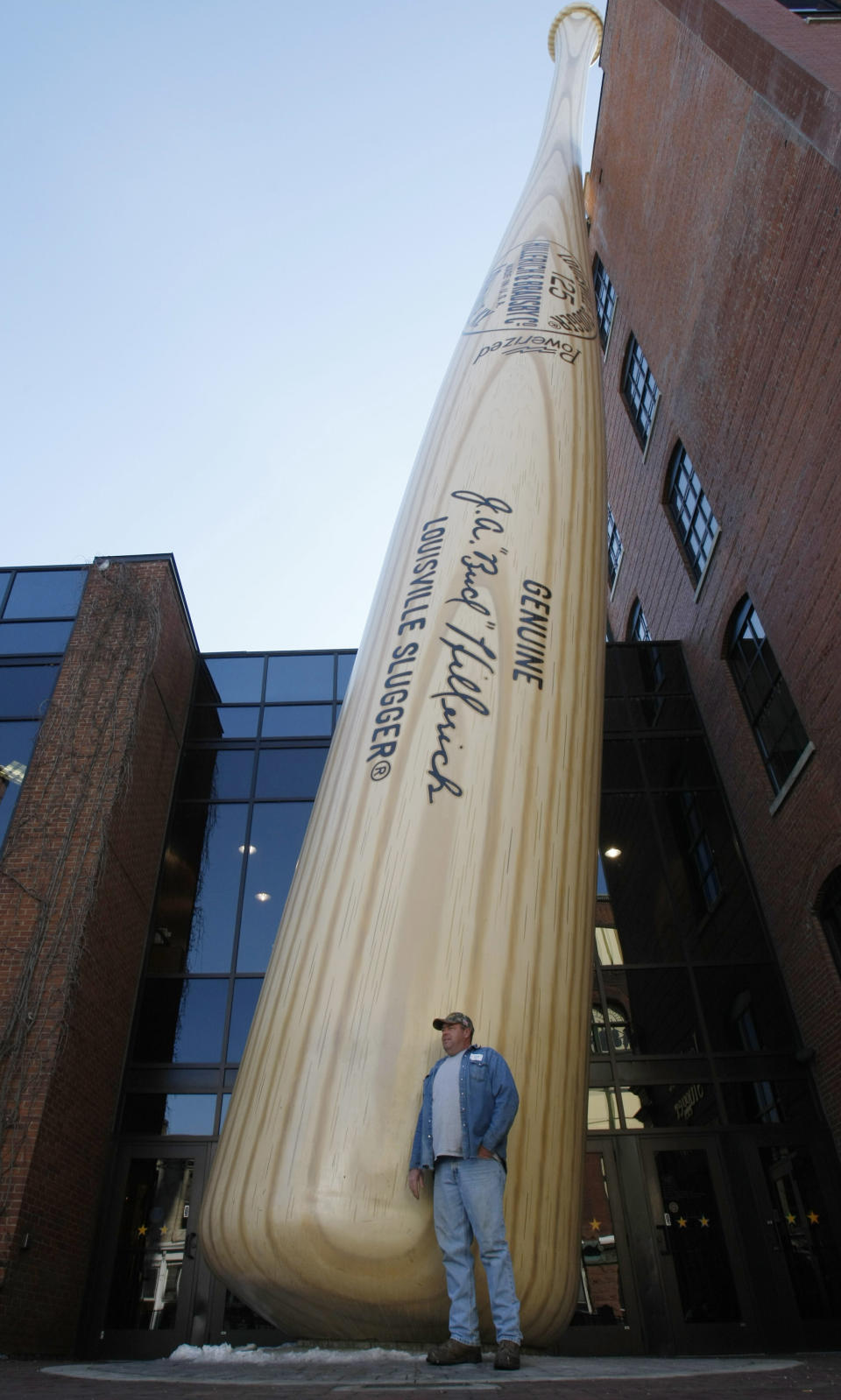 FILE - In this Friday, Feb. 19, 2010 file photo, Bland McCall of Bennettsville, S.C., poses for a photograph in front of the iconic Louisville Slugger bat at the Louisville Slugger Museum & Factory in Louisville, Ky. Although Louisville is best-known for the Derby, visitors in town for the May 5, 2012 race will find plenty of other things to do and see around town, from museums to historic hotels to trendy restaurants. (AP Photo/Ed Reinke)