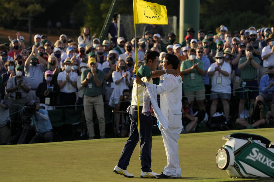 Hideki Matsuyama, of Japan, hugs his caddie Shota Hayafuji after winning the Masters golf tournament on Sunday, April 11, 2021, in Augusta, Ga. (AP Photo/Gregory Bull)