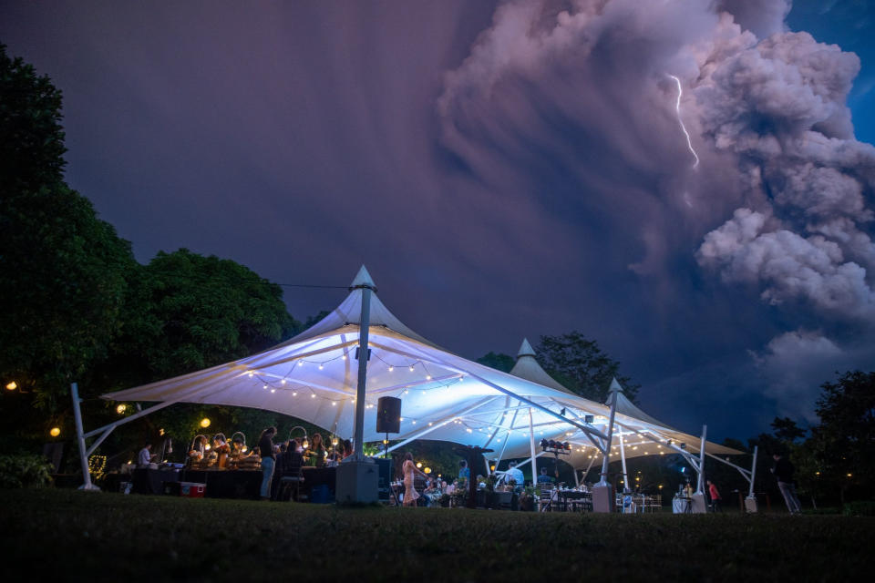 Chino Vaflor and Kat Bautista Palomar who marry in Alfonso, Cavite in the Philippines a short distance from the Taal volcano. Lightning and smoke is seen in the sky.