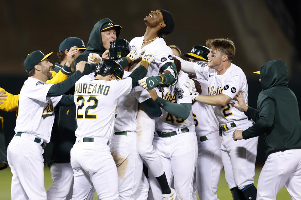 Oakland Athletics' Esteury Ruiz, center, celebrates with teammates after a game winning single during the 12th inning of a baseball game against the Arizona Diamondbacks in Oakland, Calif., Tuesday, May 16, 2023. (AP Photo/Jed Jacobsohn)