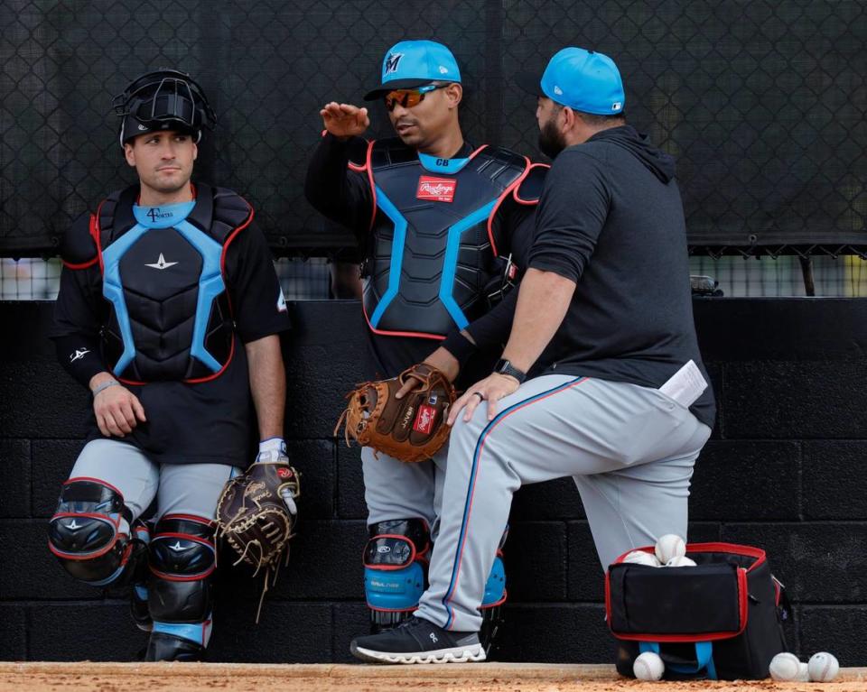 Marlins catchers Nick Fortes (left) and Christian Bethancourt (center) talk with coach Rod Barajas during Miami Marlins pitchers and catchers spring training workout at Roger Dean Chevrolet Stadium in Jupiter, Florida on Thursday, February 15, 2024.