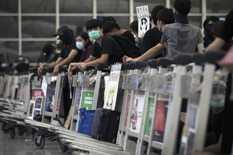 Protesters use luggage trolleys to block the departure gates during a demonstration at the Airport in Hong Kong, Tuesday, Aug. 13, 2019. (Photo: Vincent Thian/AP)