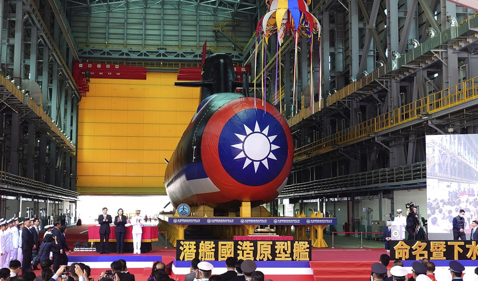 Taiwan's President Tsai Ing-wen, center, one of the three standing next to a covered submarine, attends the launching ceremony for domestically-made submarines at CSBC Corp's shipyards in Kaohsiung, Southern Taiwan, Thursday, Sept. 28, 2023. The submarine, if successful in its tests, will be a major breakthrough for Taiwan in shipbuilding and design. (AP Photo/Chiang Ying-ying)