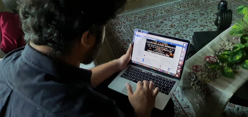 Zoraiz Riaz, who admins a Facebook group called Corona Recovered Warriors! to coordinate convalescent plasma donations, works on a computer at his residence in Lahore,