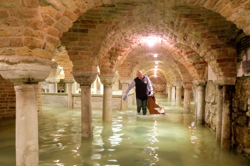 A man wades in the flooded crypt of St Mark's Basilica during a period of exceptionally high water levels in Venice, Italy