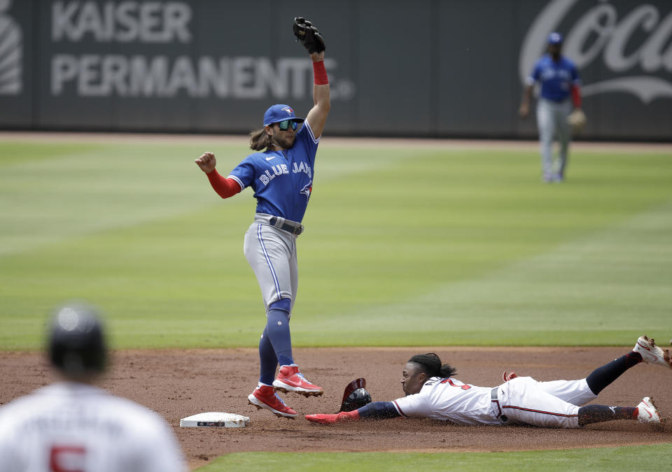 Atlanta Braves' Ozzie Albies, right, steals second base beneath Toronto Blue Jays' Bo Bichette in the first inning of a baseball game Thursday, May 13, 2021, in Atlanta. (AP Photo/Ben Margot)