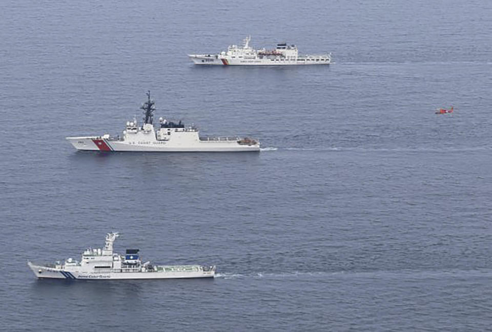 This photo provided by the Japan Coast Guard shows its patrol vessel Wakasa, from bottom, U.S. Coast Guard's cutter Waesche and (South) Korea Coast Guard's patrol vessel Taepyongyang 16 as a helicopter (in red) flies at right during a drill in waters off the northern coast of Maizuru, Japan, Thursday, June 6, 2024. The three countries' coast guard vessels conducted their first three-way drill on Thursday off Japan's coast as the countries strengthen their maritime ties in response to increased assertiveness by China in pressing its territorial claims. (Japan Coast Guard via AP)