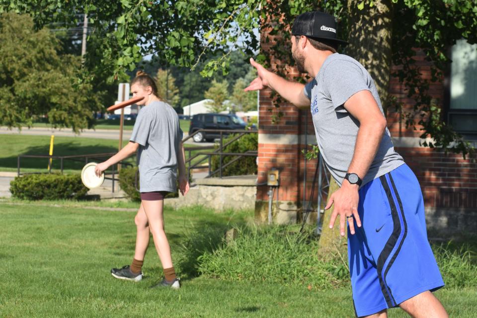 Blake, right, and Dani Hohlbein of Adrian throw some practice shots Thursday at the disc golf course on the PlaneWave Instruments campus in Adrian.