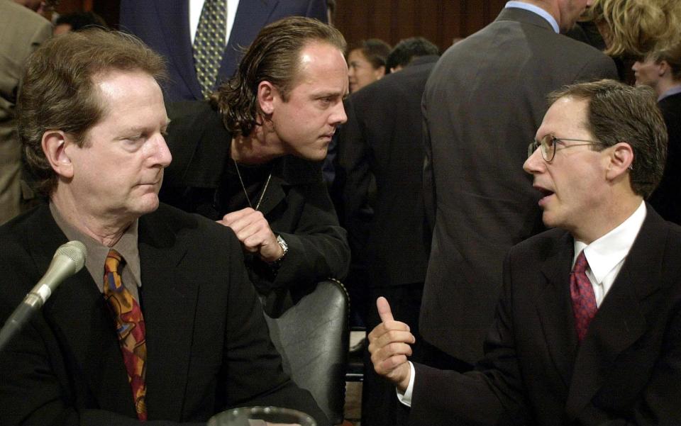 Drummer Lars Ulrich (C) of the hard rock band Metallica and Roger McGuinn (L) of the band The Byrds speak with Hank Berry (R) CEO of Napster before their testimony before the US Senate Judiciary Committee on July 11, 2000 in Washington, DC.