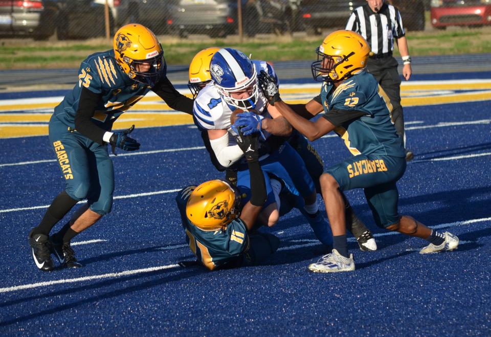 Harper Creek's Nate Jackson is tackled by a group of BCC defenders during this city rivalry game at C.W. Post Field on Friday.