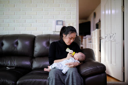 Kim Mi-sung feeds her baby son at their home in Seoul, South Korea, December 19, 2018. REUTERS/Kim Hong-Ji