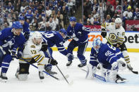 Toronto Maple Leafs' goaltender Joseph Woll (60) makes a save against Boston Bruins' Charlie Coyle (13) as Maple Leafs' Max Domi (11) defends and Bruins' Brad Marchand (63) and Maple Leafs' Morgan Rielly (44) look on during the third-period action in Game 6 of an NHL hockey Stanley Cup first-round playoff series in Toronto, Thursday, May 2, 2024. (Nathan Denette/The Canadian Press via AP)