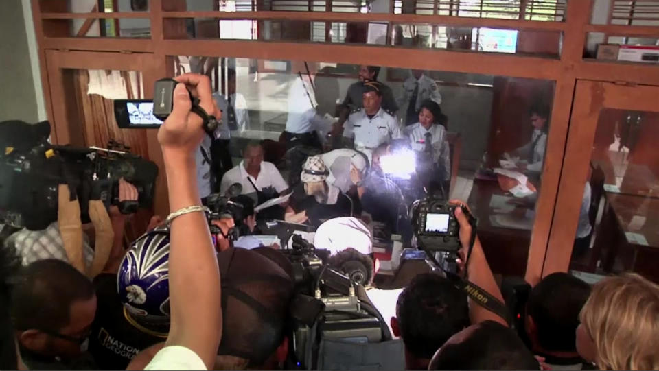 In this video image taken from AP video, Australian Schapelle Corby, center, listens to an official at Prosecutors Office after receiving her parole in Bali, Indonesia, Monday, Feb. 10, 2014. The Australian woman convicted of smuggling marijuana into Indonesia walked free from jail on Monday after being given parole, the latest chapter in what has been a media sensation in her home country since her arrest on the tourist island of Bali in 2005. Corby's case captured the imagination of many in Australia, where initial sympathy for her plight and nationalist outrage in the aftermath of two terrorist attacks targeting Australian interests in the country made for a potent combination for popular and highbrow media alike. (AP Photo via AP video)