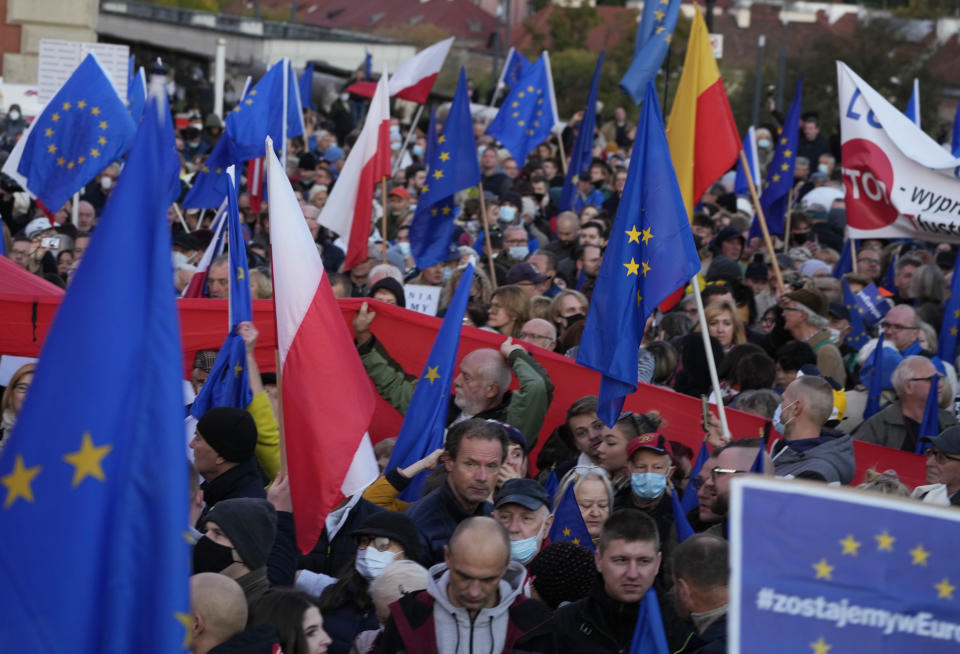 People wave EU and Polish flags in support of Poland's EU membership during a demonstration, in Warsaw, Poland, Sunday, October 10, 2021. Poland's constitutional court ruled Thursday that Polish laws have supremacy over those of the European Union in areas where they clash, a decision likely to embolden the country's right-wing government and worsen its already troubled relationship with the EU. (AP Photo/Czarek Sokolowski)