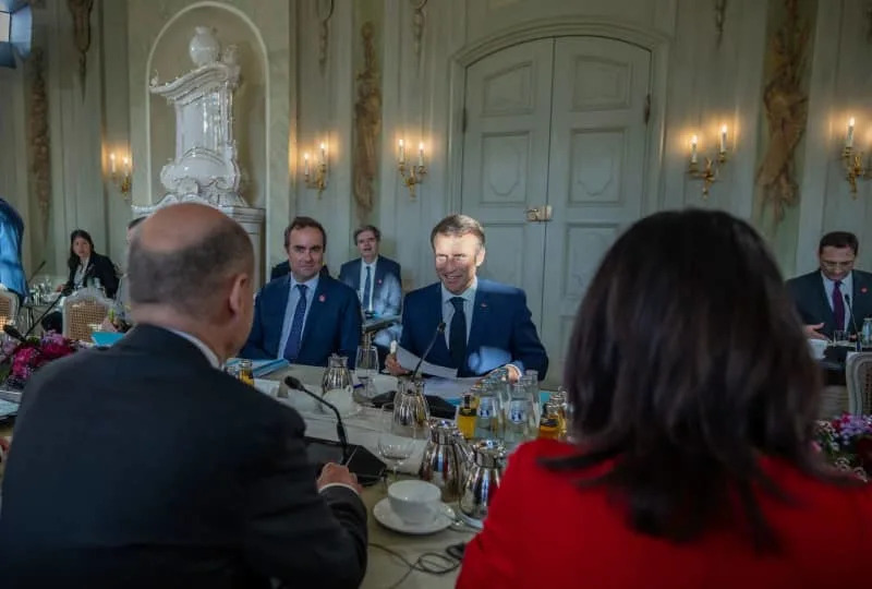 Germany's Chancellor Olaf Scholz (L), sits next to Annalena Baerbock (R), Germany's Foreign Minister, opposite Emmanuel Macron, France's President, at the working session at the Franco-German Council of Ministers in front of Schloss Meseberg, the Germany's Government's guest house. Michael Kappeler/dpa-Pool/dpa