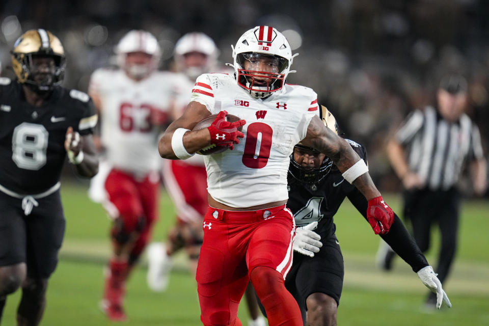 Wisconsin running back Braelon Allen (0) outruns Purdue linebacker Kydran Jenkins (4) for a first down during the second half of an NCAA college football game in West Lafayette, Ind., Friday, Sept. 22, 2023. (AP Photo/Michael Conroy)