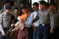 Detained Reuters journalist Kyaw Soe Oo hugs his daughter as he is escorted by police, arrives for a court hearing in Yangon, Myanmar. REUTERS/Stringer