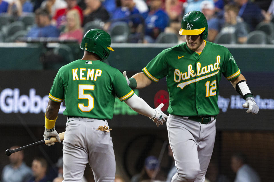 Oakland Athletics' Sean Murphy (12) is congratulated by teammate Tony Kemp after hitting a home run during the fifth inning of a baseball game against the Texas Rangers, Monday, June 21, 2021, in Arlington, Texas. (AP Photo/Sam Hodde)