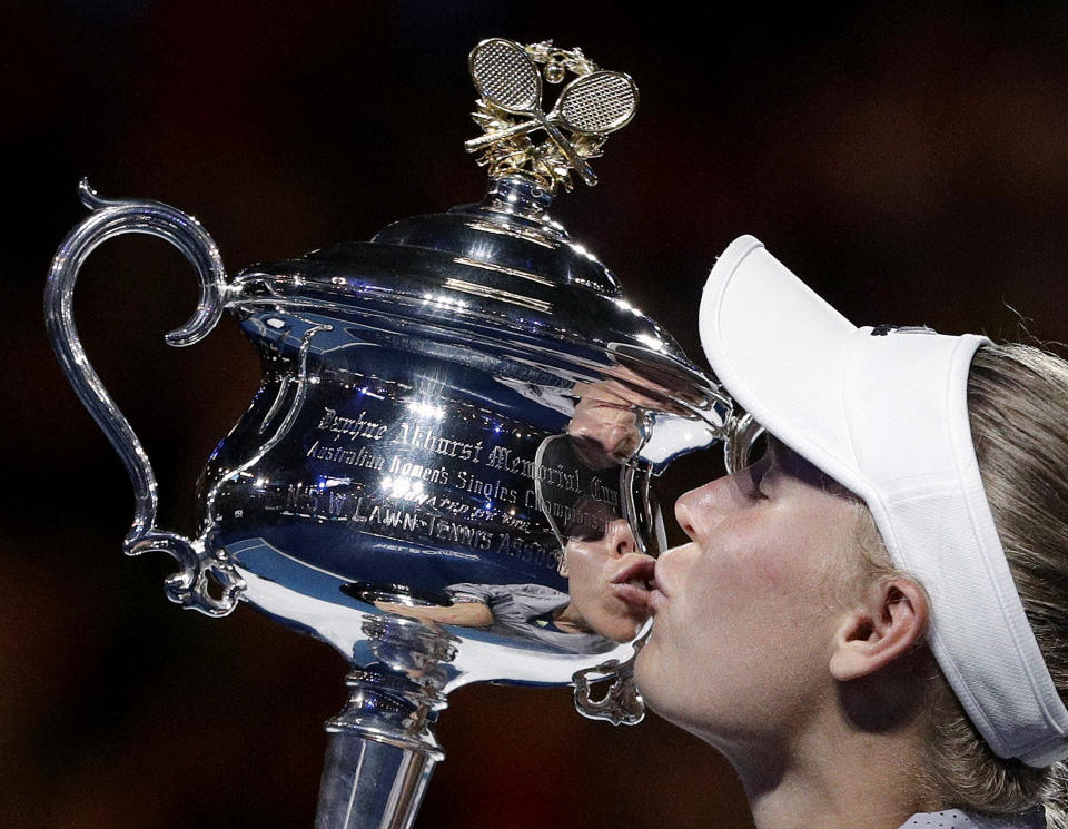 FILE - Denmark's Caroline Wozniacki kisses her trophy after defeating Romania's Simona Halep in the women's singles final at the Australian Open tennis championships in Melbourne, Australia, Saturday, Jan. 27, 2018. Wozniacki, a former No. 1-ranked tennis player and the 2018 Australian Open champion, announced Thursday, June 29, 2023, that she is returning to competition three years after she retired. (AP Photo/Dita Alangkara, File)