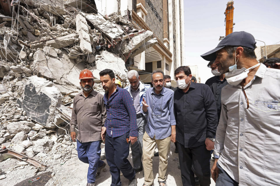 In this photo released by official website of the office of Iranian Senior Vice-President, on Friday, May 27, 2022, Vice-President Mohammad Mokhber, second right, visits the site of a tower at under construction 10-story Metropol Building which collapsed on Monday, in the southwestern city of Abadan, Iran. Rescue teams at the site of the tower pulled five more bodies from the rubble on Friday, bringing the death toll in the disaster to 24. (Iranian Senior Vice-President Office via AP)