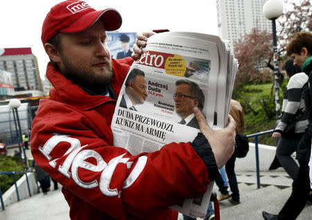 A newsboy distributes newspapers a day after the first round of the Polish presidential elections at city center in Warsaw, Poland May 11, 2015. REUTERS/Kacper Pempel