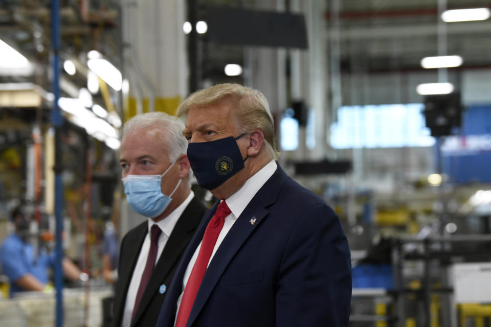 President Donald Trump wears a mask as he gets a tour of the Whirlpool Corporation facility from Jim Keppler, Vice President, Integrated Supply Chain and Quality, Whirlpool Corporation in Clyde, Ohio, Thursday, Aug. 6, 2020. Trump is in Ohio to promote the economic prosperity that much of the nation enjoyed before the coronavirus pandemic and try to make the case that he is best suited to rebuild a crippled economy. (AP Photo/Susan Walsh)
