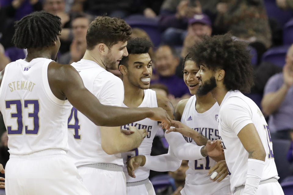 Washington's Isaiah Stewart (33), Sam Timmins, Jamal Bey, RaeQuan Battle and Marcus Tsohonis smile as they huddle after a score against Stanford in the first half of an NCAA college basketball game Thursday, Feb. 20, 2020, in Seattle. (AP Photo/Elaine Thompson)