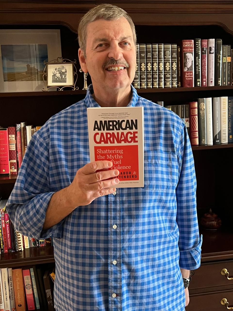 Tom Gabor poses with a copy of his and Fred Guttenberg's book "American Carnage: Shattering the Myths that Fuel Gun Violence."