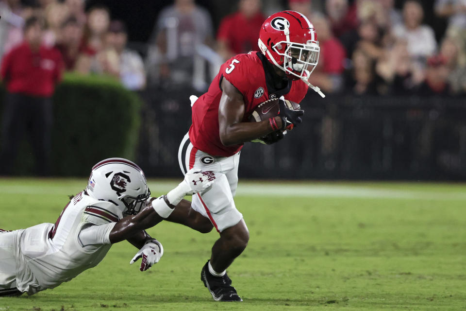 Georgia wide receiver Adonai Mitchell (5) breaks free from the arms of South Carolina defensive back Cam Smith (9) after catching a pass during the first half of an NCAA college football game Saturday, Sept. 18, 2021, in Athens, Ga. (AP Photo/Butch Dill)