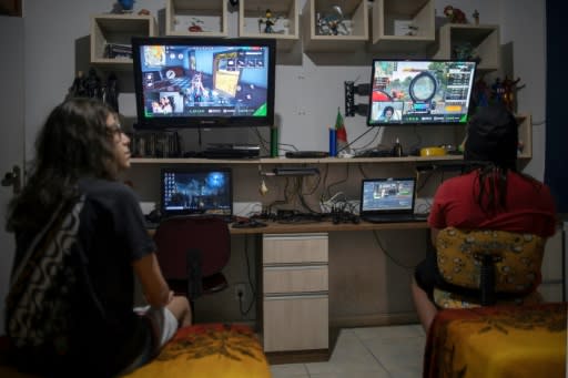 Brothers Guilherme (L), 14, and Arthur, 11, watch professional players from YouTube channel Loud play the mobile game Free Fire, at their house in Rio de Janeiro, Brazil