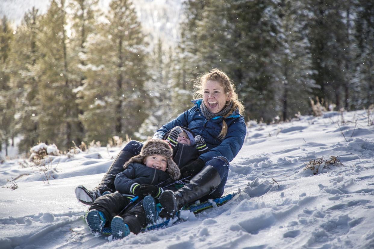 mom and two kids going down Mount Charleston in a sled