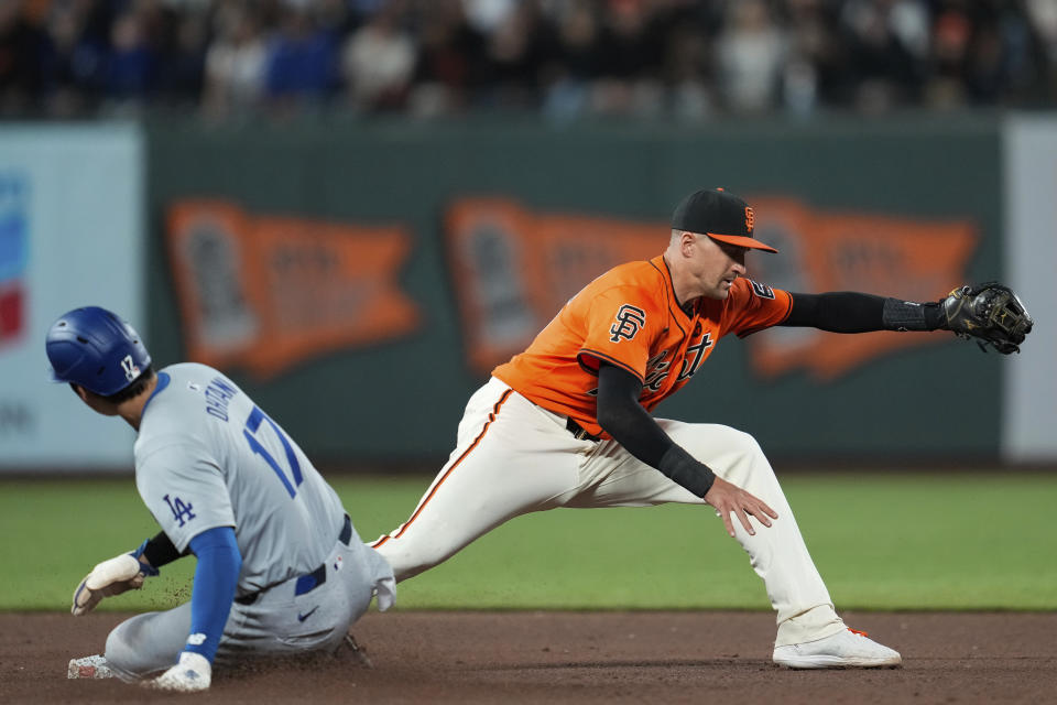 San Francisco Giants shortstop Nick Ahmed, right, catches a throw from second baseman Brett Wisely to force out Los Angeles Dodgers' Shohei Ohtani, left, during the eighth inning of a baseball game Friday, June 28, 2024, in San Francisco. Freddie Freeman reached first on the play. (AP Photo/Godofredo A. Vásquez)