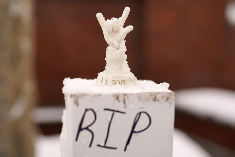 A small statue depicting "I love you" in sign language is seen Tuesday, Dec. 5, 2023, at a makeshift memorial for the victims of last month's mass shooting in Lewiston, Maine. Among the 18 people killed were several members of Maine's deaf community. Items from the memorials will be cataloged, archived and displayed in a museum. (AP Photo/Robert F. Bukaty)