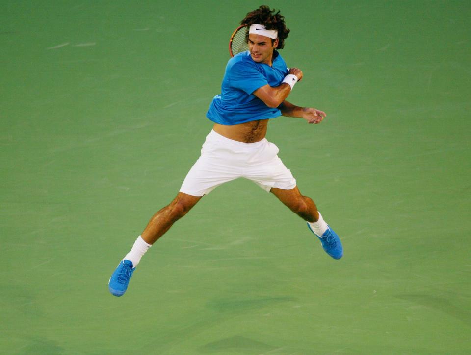 2005: Roger Federer hits a return to Andre Agassi during their Australian Open quarterfinals match.