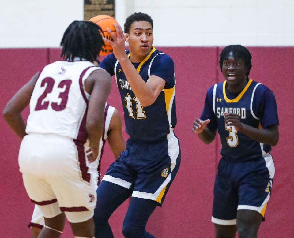 Sanford's Jayden Taylor (11) snags a rebound in front of teammate Khareem Hart in the first half of the Warriors' 58-51 win at the St. E Center on Feb. 16. St. Elizabeth earned the No. 1 seed in the DIAA Boys Basketball Tournament when the brackets were released Friday, with Sanford taking the No. 5 seed.