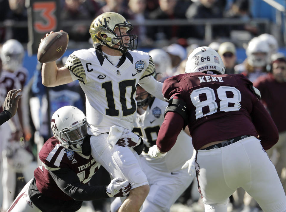 Wake Forest’s John Wolford (10) looks to pass under pressure from against Texas A&M’s Kingsley Keke (88) during the first half of the Belk Bowl NCAA college football game in Charlotte, N.C., Friday, Dec. 29, 2017. (AP Photo/Chuck Burton)