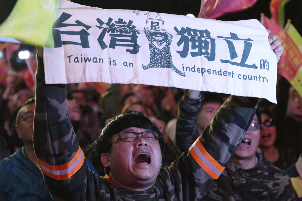 In this Jan. 11, 2020, photo, a supporter of Taiwan's presidential election candidate, Taiwan president Tsai Ing-wen cheers for her victory and holds a slogan reading "Taiwan Is An Independent Country" in Taipei, Taiwan, Saturday, Jan. 11, 2020. (AP Photo/Chiang Ying-yin, File)