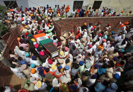 People carry a coffin containing the body of Paramjit Singh, an Indian army soldier who the Indian army says was killed by Pakistani soldiers while patrolling the de facto border in the disputed Kashmir region on Monday, before his cremation in the village of Vein Poin on the outskirts of Amritsar, India May 2, 2017. REUTERS/Munish Sharma