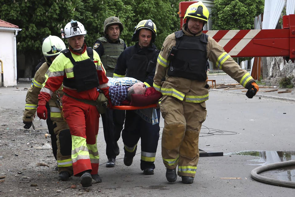 In this photo provided by the Ukrainian Emergency Service, rescuers and ambulance workers carry a person at the scene of a Russian attack in Dnipro, Ukraine, Friday, April 19, 2024. (Ukrainian Emergency Service via AP Photo)