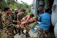 A Nepal Army personnel carries an injured woman to an Indian Airforce helicopter following Saturday's earthquake in Sindhupalchowk, Nepal, April 28, 2015. REUTERS/Danish Siddiqui