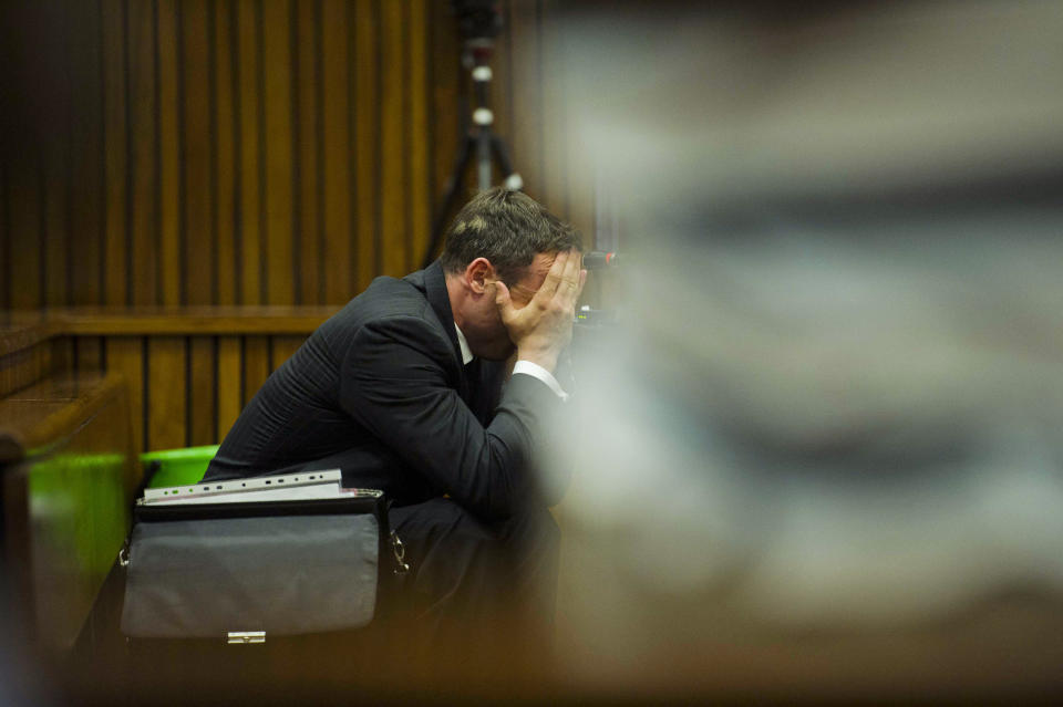 Oscar Pistorius covers his face with his hands as he listens to forensic evidence during his trial in court in Pretoria, South Africa, Thursday, March 13, 2014. Pistorius is charged with the shooting death of his girlfriend Reeva Steenkamp, on Valentines Day in 2013. (AP Photo/Alet Pretorius, Pool)