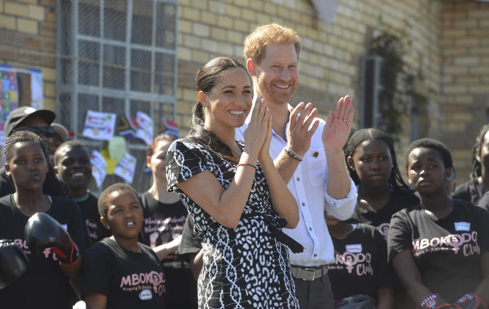 Britain's royal couple Prince Harry and Meghan Duchess of Sussex, greet youths on a visit to the Nyanga Methodist Church in Cape Town, South Africa, Monday, Sept, 23, 2019, which houses a project where children are taught about their rights, self-awareness and safety, and are provided self-defence classes and female empowerment training to young girls in the community. The royal couple are starting their first official tour as a family with their infant son, Archie (Courtney Africa / Africa News Agency via AP, Pool)