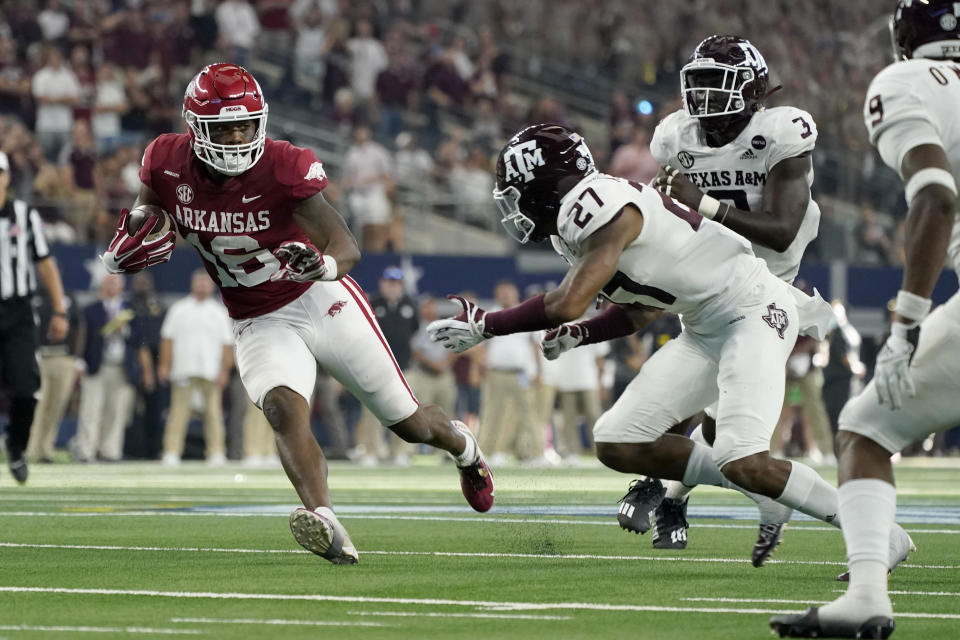 Arkansas wide receiver Treylon Burks (16) attempts to evade a tackle by Texas A&M defensive back Antonio Johnson (27), defensive lineman Tyree Johnson (3) and defensive back Leon O'Neal Jr. (9) in the second half of an NCAA college football game in Arlington, Texas, Saturday, Sept. 25, 2021. (AP Photo/Tony Gutierrez)