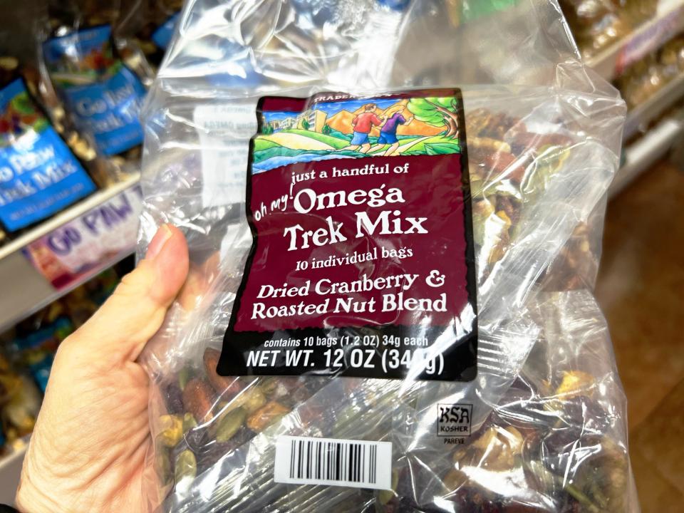 The writer holds clear bags of Omega trek mix with dried cranberries and roasted nuts