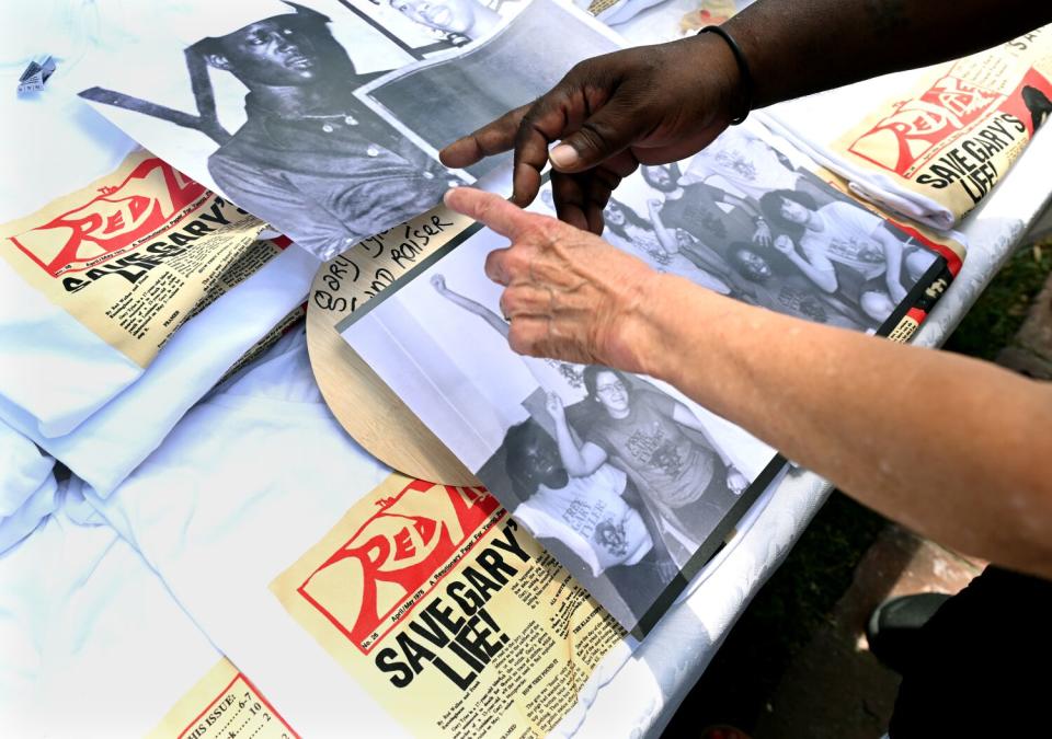 Gary Tyler points to photos and mementos