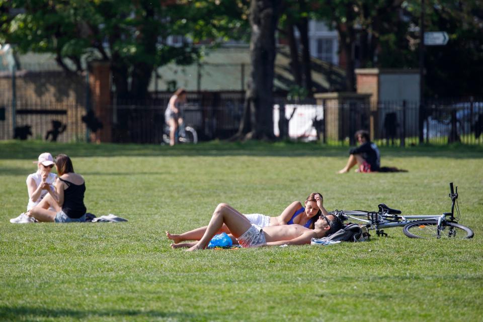 People sunbathe at London Fields in east London on April 24, 2020, during the national lockdown due to the novel coronavirus COVID-19 pandemic. - British Prime Minister Boris Johnson, who is recovering after contracting the new coronavirus, is "in very good shape", Health Secretary Matt Hancock said on Friday. (Photo by Tolga AKMEN / AFP) (Photo by TOLGA AKMEN/AFP via Getty Images)